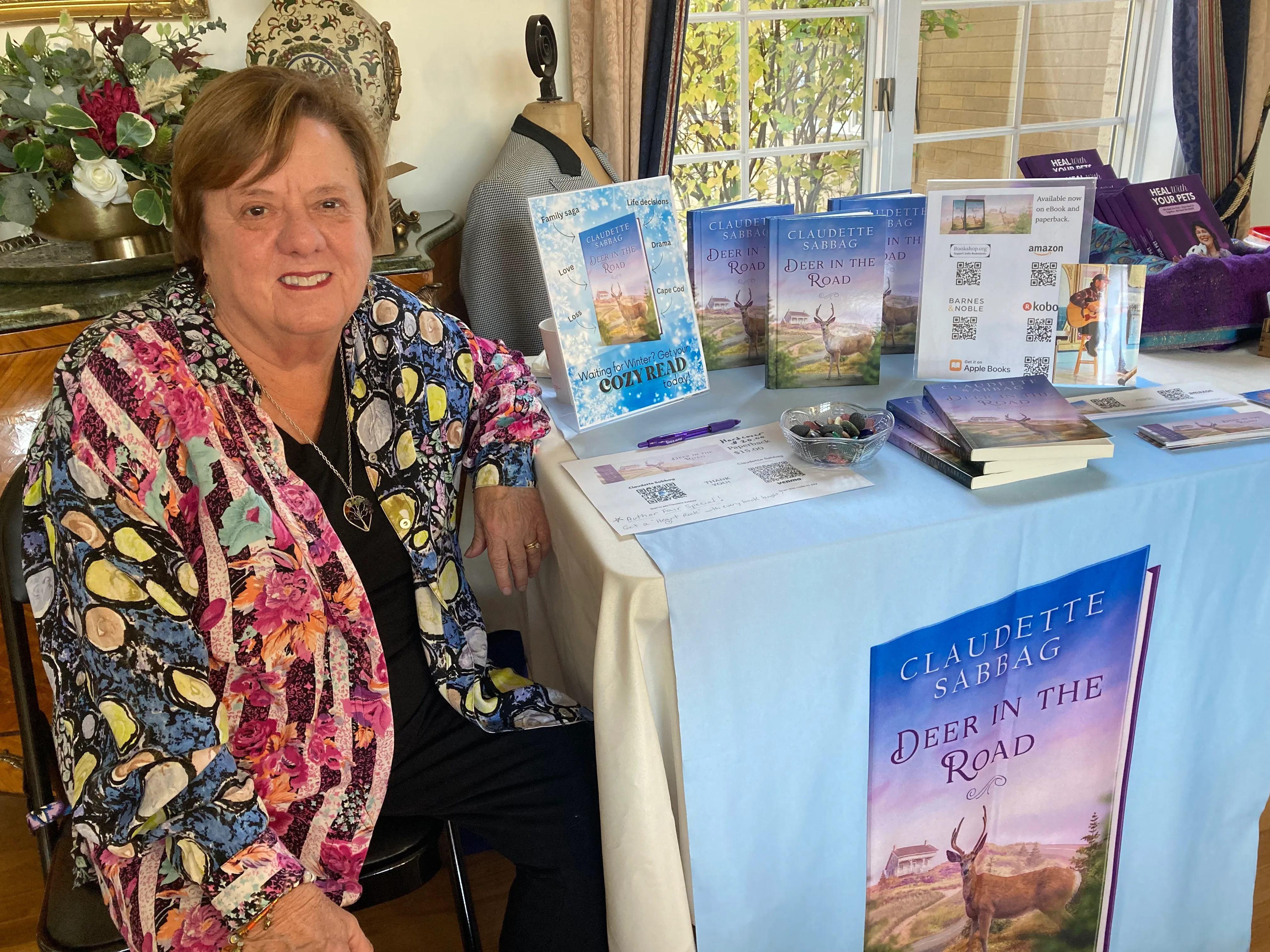 Claudette at an author table at a book fair